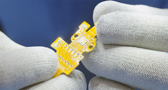 Closeup of a worker holding a tiny circuit board